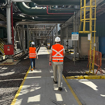 Workers walking through an industrial processing facility